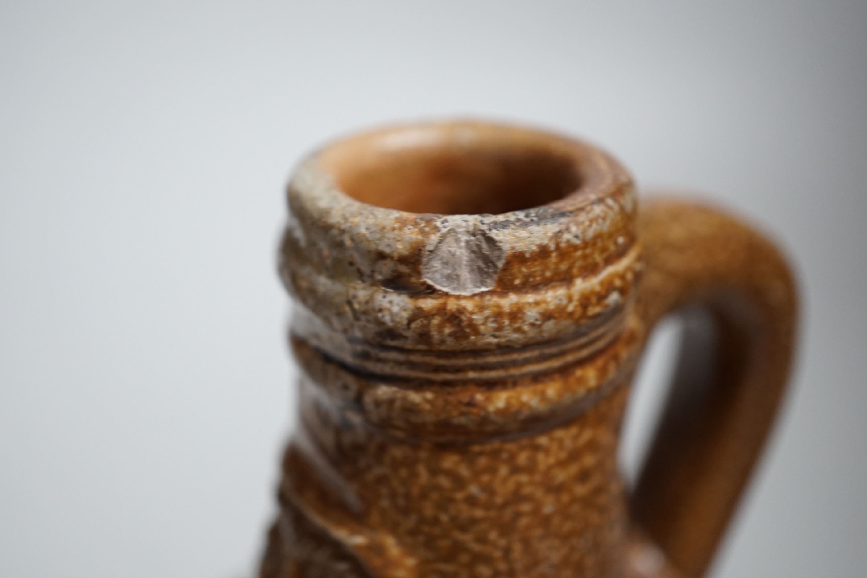 A 17th century stoneware Bellarmine or Bartmann jug, 21cm